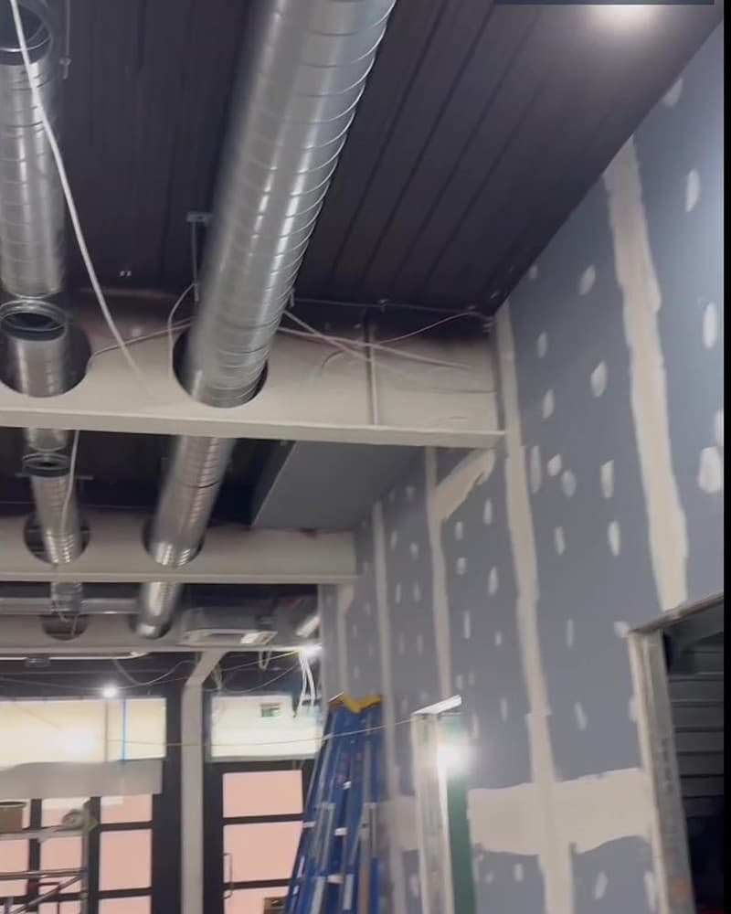 Restaurant fit-out on site with ductwork installed above the dining area