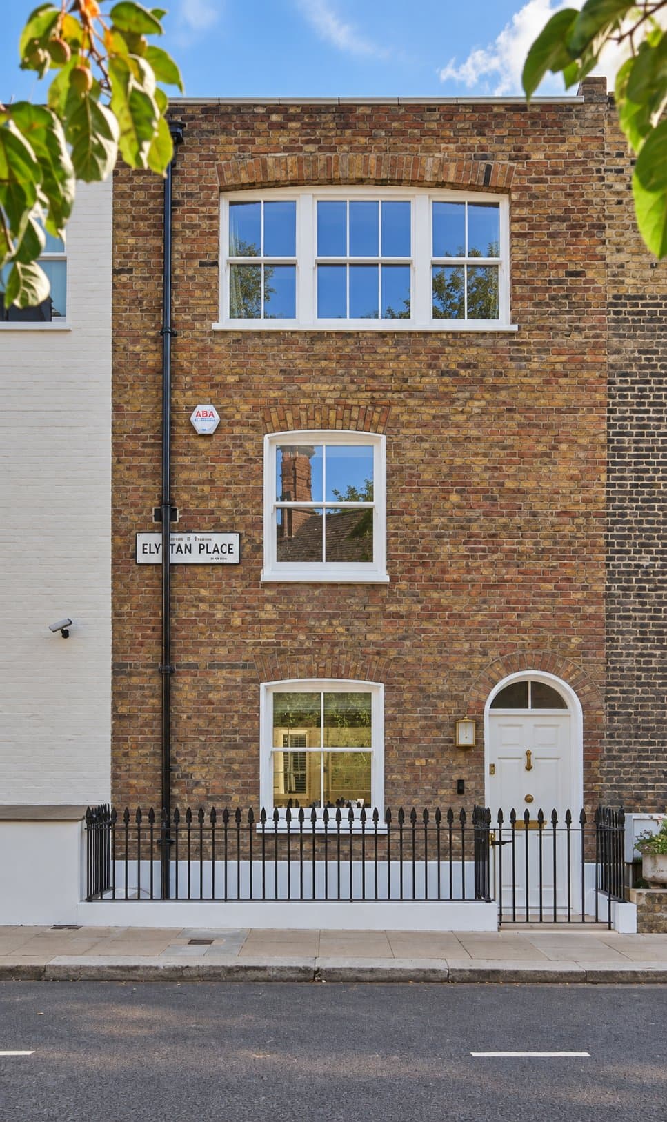 Street elevation of the refurbished town house at Elystan Place, Chelsea: stock brick with white sash windows and an arched front door