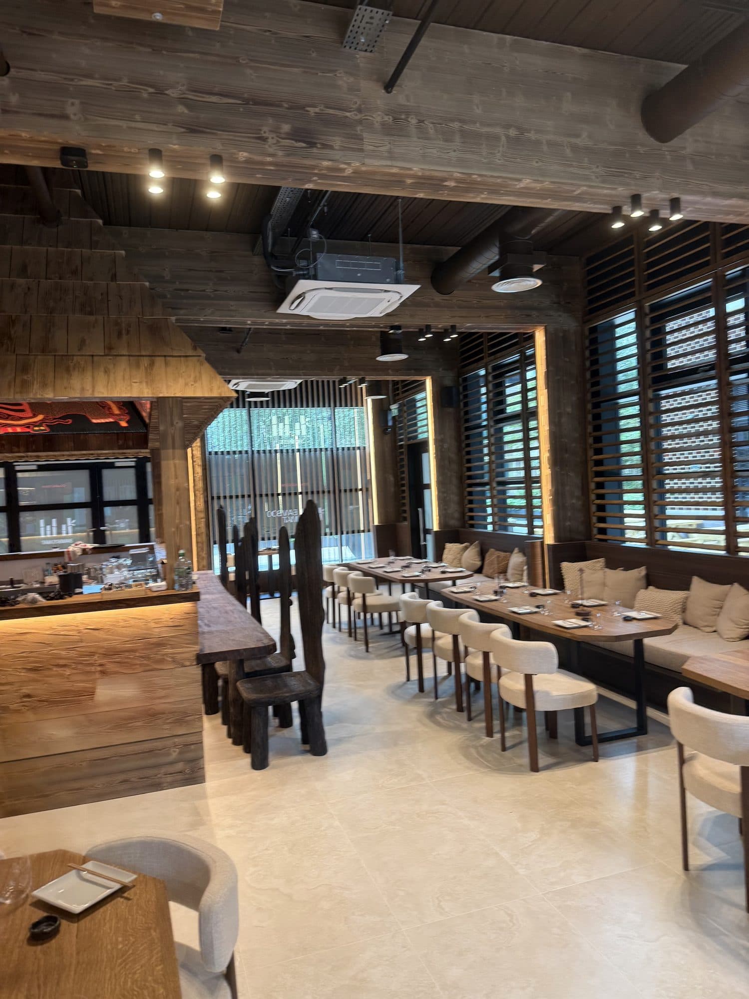 The dining room looking towards the entrance, with banquette seating under the louvred windows